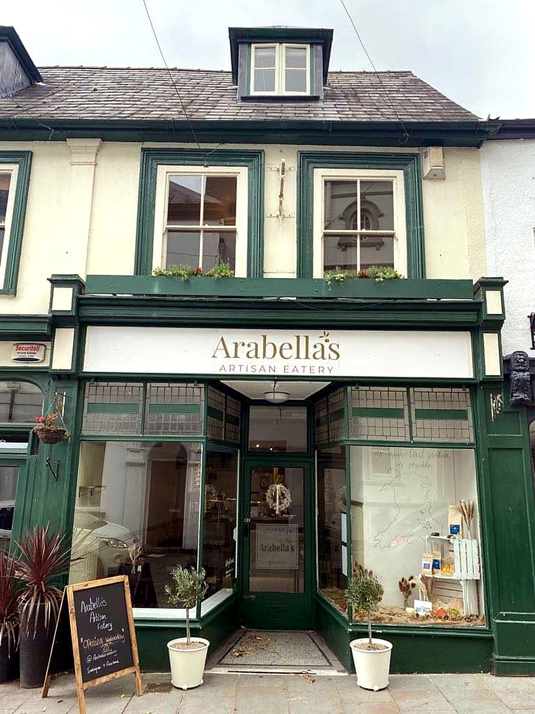 Arabella's on Brecon High Street: a bottle-green shopfront with a cream sign reading Arabella's Artisan Eatery, a chalkboard and potted plants by the door